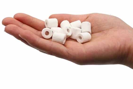 A person's hand holding white ceramic rings